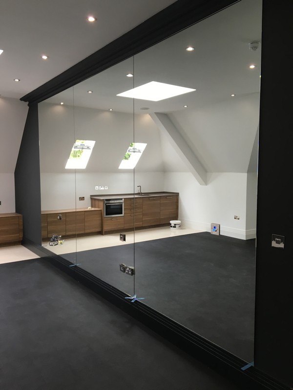 Frameless glass partition in loft conversion by Fulham glaziers