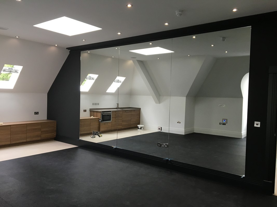 Frameless glass wall dividing loft conversion in Fulham